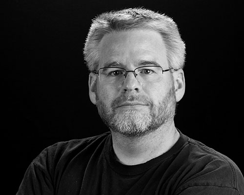 A black and white portrait of Dan MacDonald
