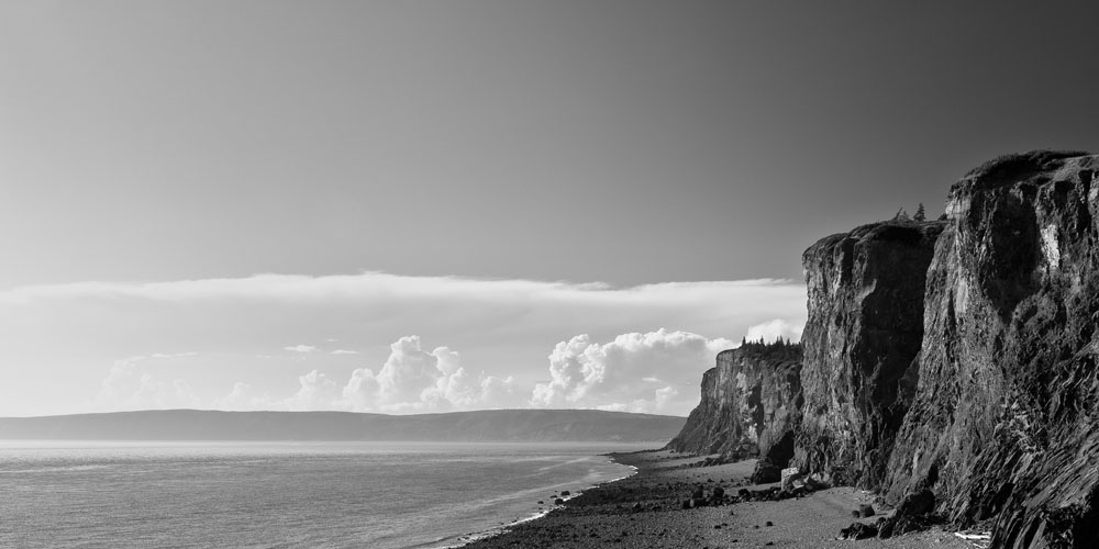A line of cliffs stretches into the distance with some covered by low-lying clouds